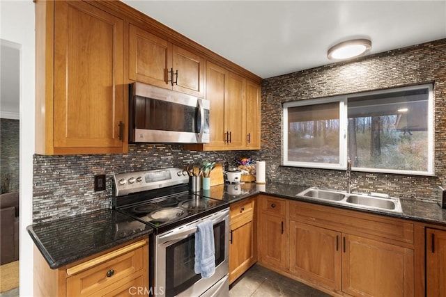 kitchen featuring backsplash, sink, stainless steel appliances, and dark stone counters