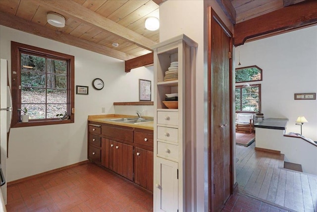 bathroom featuring beamed ceiling, sink, and wooden ceiling