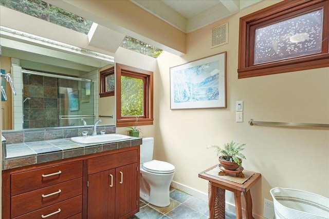 bathroom with vanity, toilet, and an enclosed shower