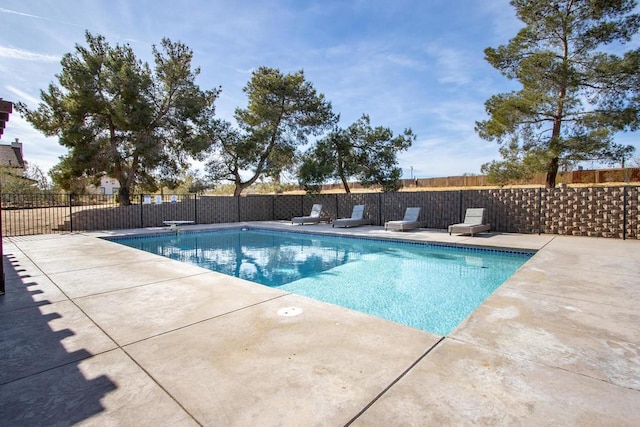 view of swimming pool featuring a diving board and a patio area