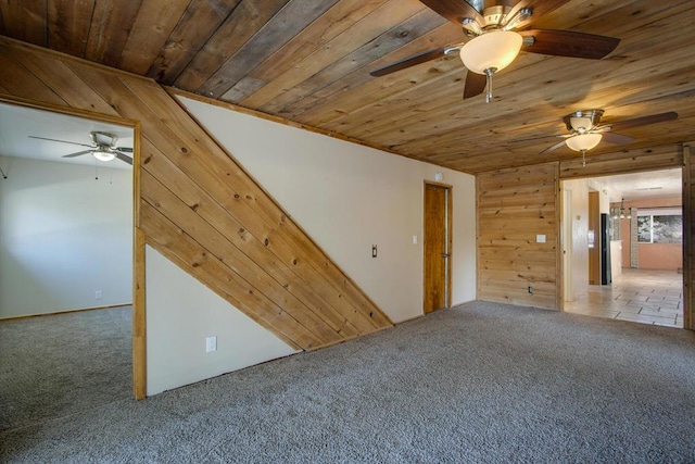 unfurnished room with carpet flooring, wooden ceiling, and wood walls