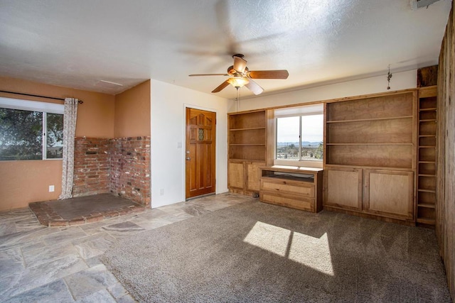 unfurnished bedroom featuring carpet flooring, ceiling fan, and a textured ceiling