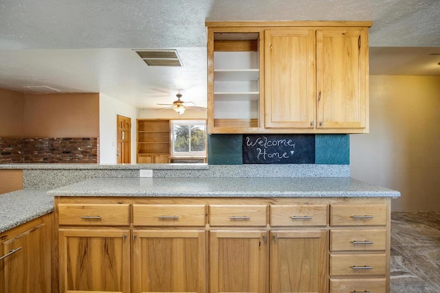 kitchen with backsplash, light stone counters, and ceiling fan