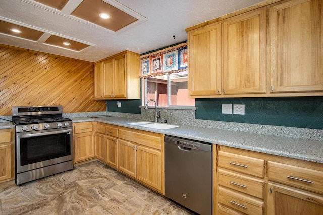 kitchen featuring wood walls, sink, and stainless steel appliances