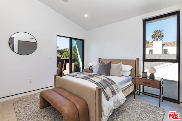 bedroom with access to exterior, vaulted ceiling, and light hardwood / wood-style floors