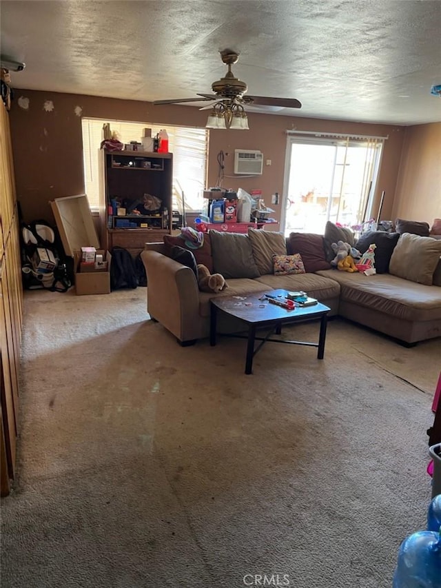 living room featuring ceiling fan, carpet floors, a textured ceiling, and a wall unit AC