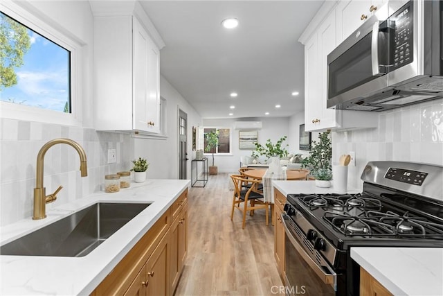 kitchen with sink, white cabinets, a healthy amount of sunlight, and appliances with stainless steel finishes