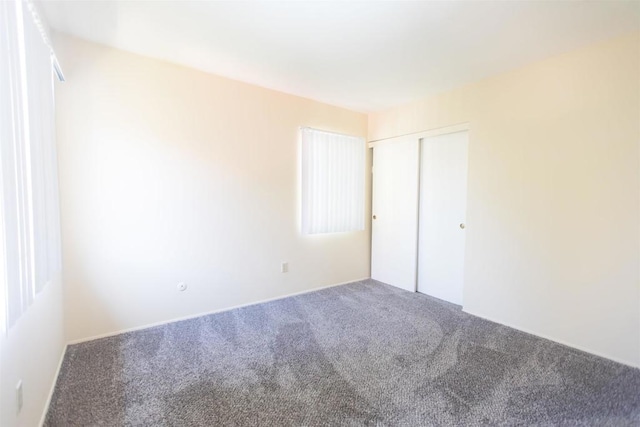 unfurnished bedroom with carpet floors and a closet