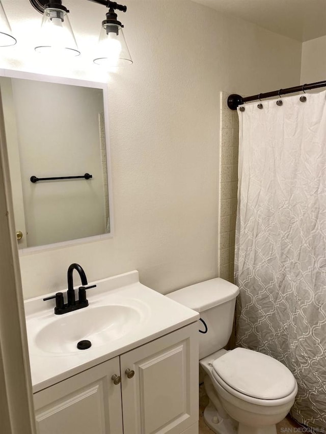 bathroom featuring a shower with curtain, vanity, and toilet