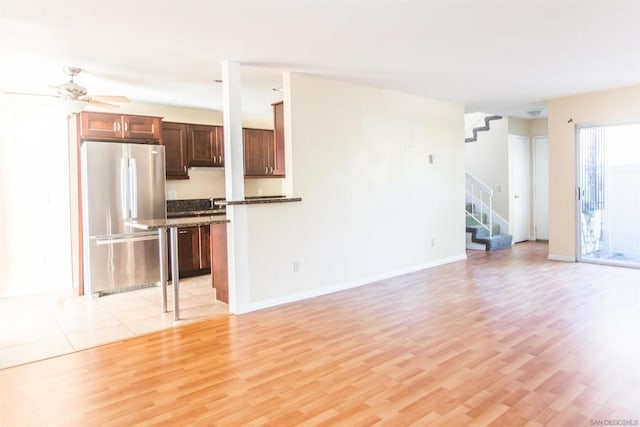 unfurnished living room featuring light hardwood / wood-style floors and ceiling fan