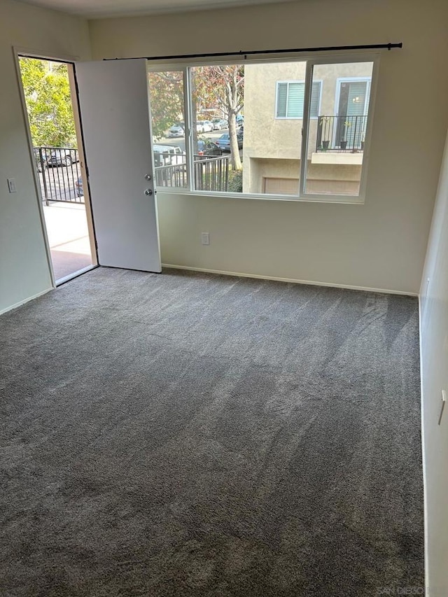 carpeted spare room featuring plenty of natural light