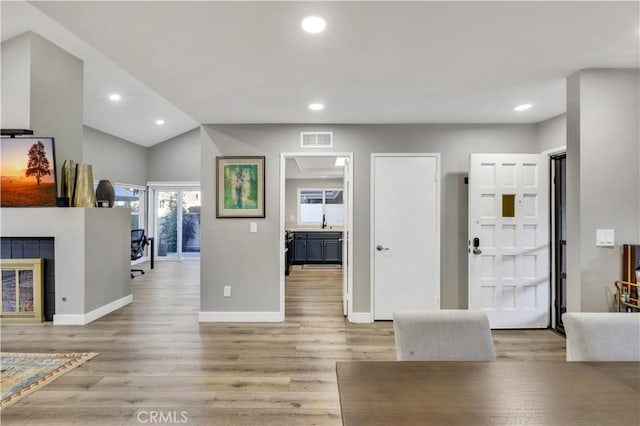 foyer featuring a tile fireplace and light wood-type flooring