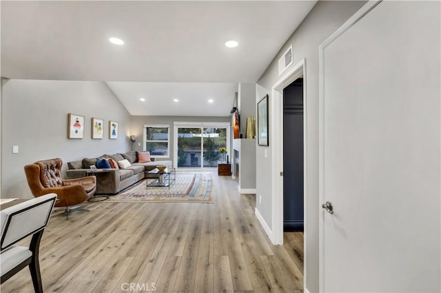 living room with lofted ceiling and light wood-type flooring