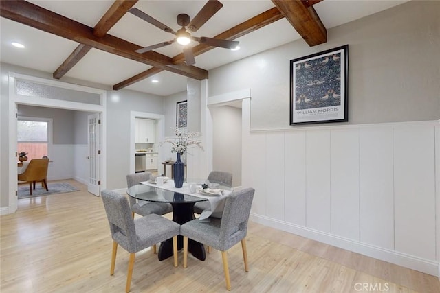 dining area with ceiling fan, beam ceiling, and light wood-type flooring