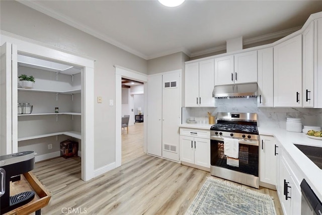 kitchen featuring decorative backsplash, white cabinets, light wood-type flooring, and appliances with stainless steel finishes