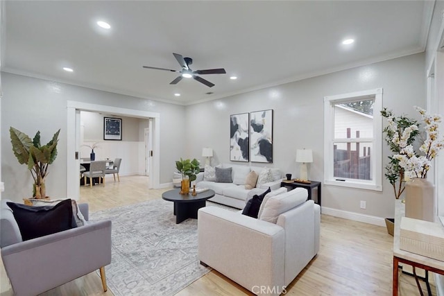 living room featuring ceiling fan, light wood-type flooring, and ornamental molding