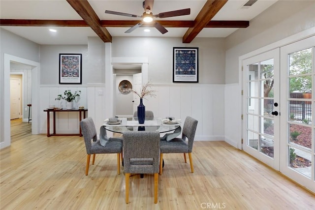 dining space with beamed ceiling, light hardwood / wood-style flooring, and french doors