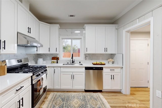 kitchen featuring light wood-type flooring, white cabinetry, sink, and appliances with stainless steel finishes