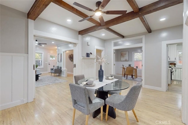 dining room with beam ceiling, light hardwood / wood-style floors, and ceiling fan