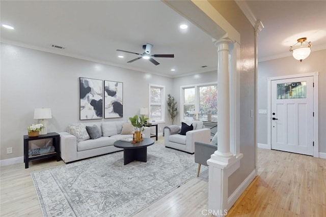 living room featuring light wood-type flooring, ornate columns, and ceiling fan