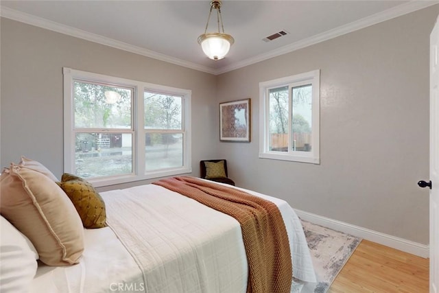 bedroom with hardwood / wood-style floors and crown molding