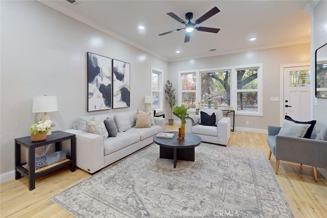 living room featuring light hardwood / wood-style flooring, ceiling fan, and ornamental molding