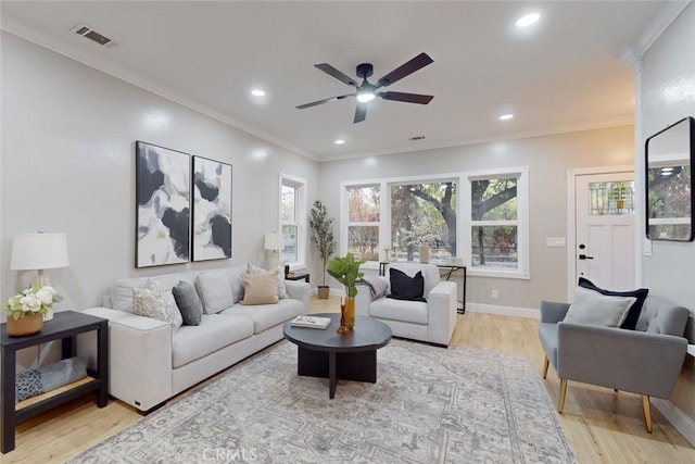 living room featuring light hardwood / wood-style floors, ceiling fan, and crown molding