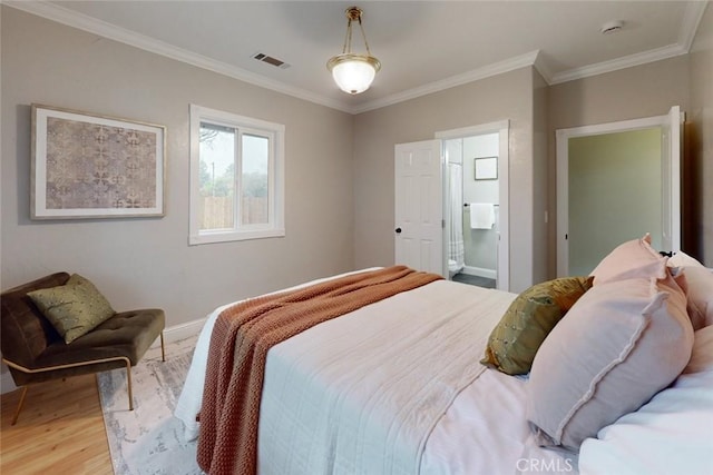 bedroom with hardwood / wood-style floors, ornamental molding, and connected bathroom