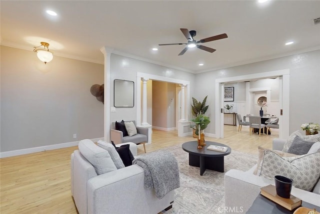 living room with ceiling fan, light hardwood / wood-style floors, ornamental molding, and ornate columns