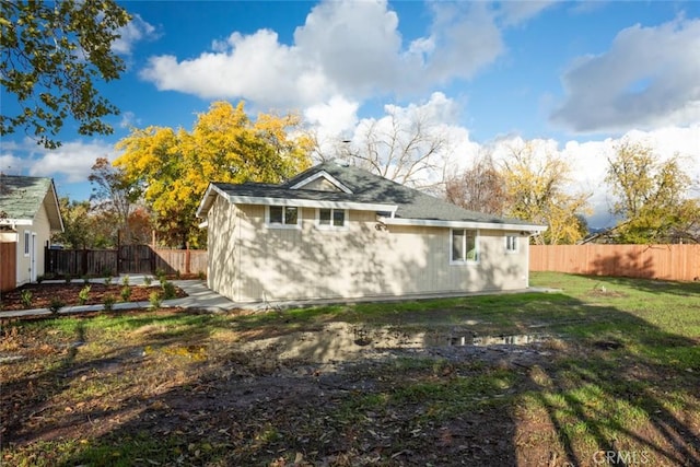 rear view of property featuring a lawn