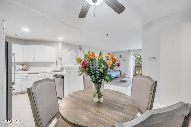 dining room with ceiling fan, light tile patterned floors, and sink