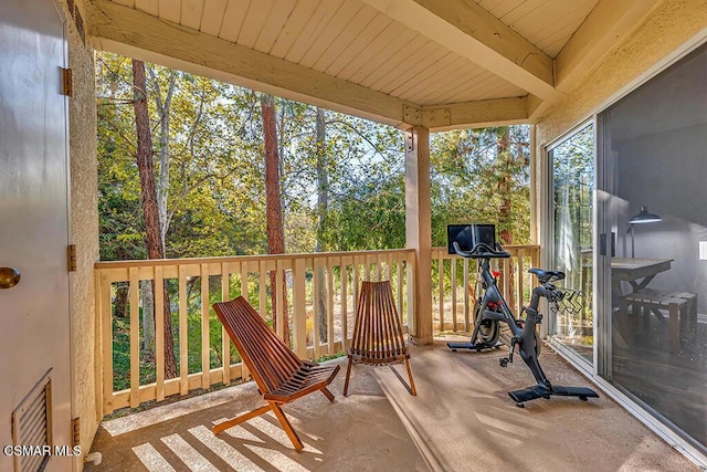 sunroom / solarium featuring beamed ceiling