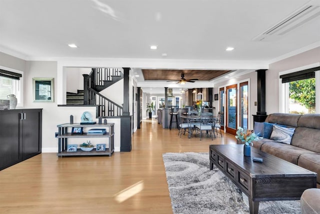 living room featuring light hardwood / wood-style floors, crown molding, and ceiling fan