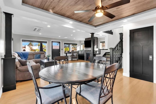 dining area with wooden ceiling, light hardwood / wood-style floors, a raised ceiling, and ceiling fan