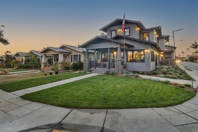 craftsman inspired home featuring a porch and a lawn