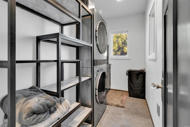 clothes washing area featuring stacked washer and clothes dryer and light tile patterned flooring