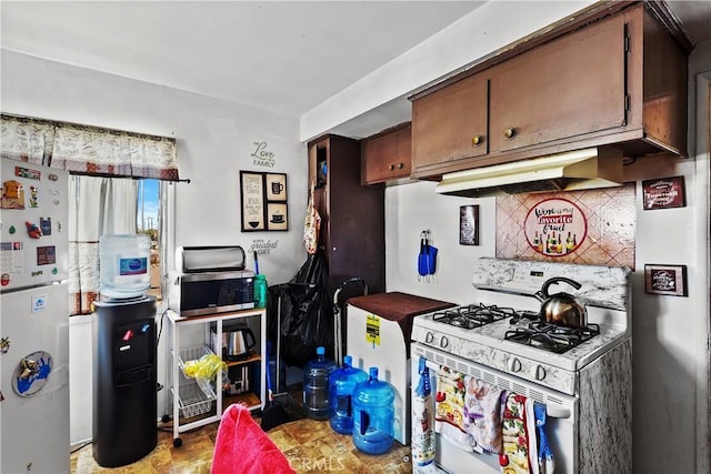 kitchen featuring white appliances, backsplash, dark brown cabinetry, and under cabinet range hood