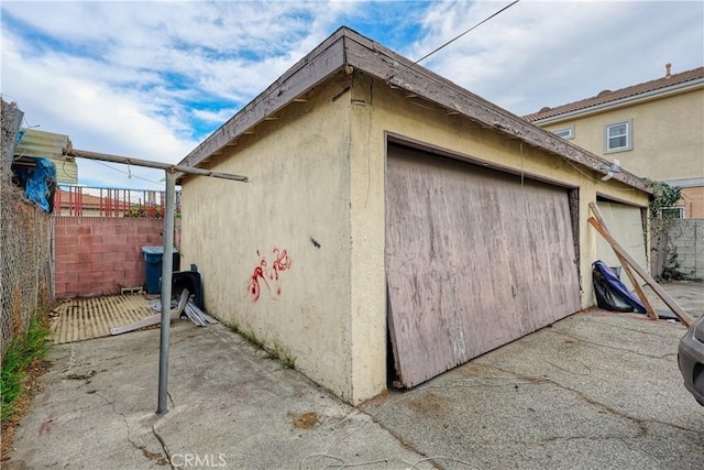 exterior space featuring an outbuilding, fence, and stucco siding