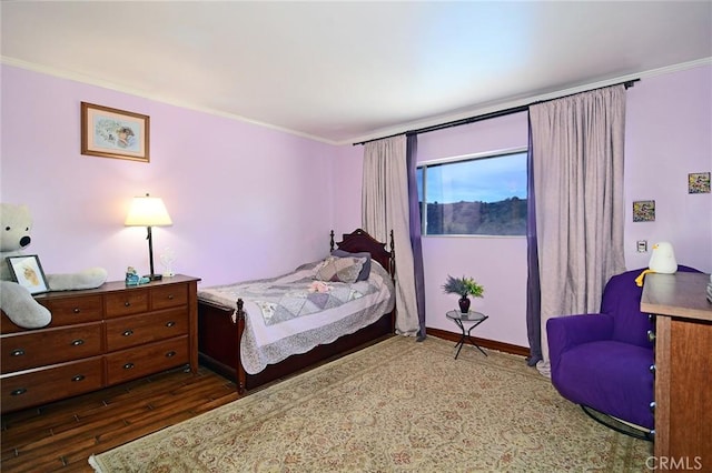 bedroom featuring wood-type flooring and ornamental molding