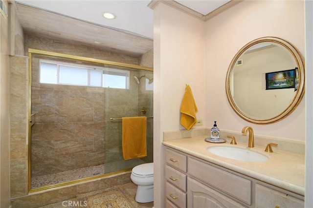 bathroom featuring vanity, a shower with shower door, and toilet