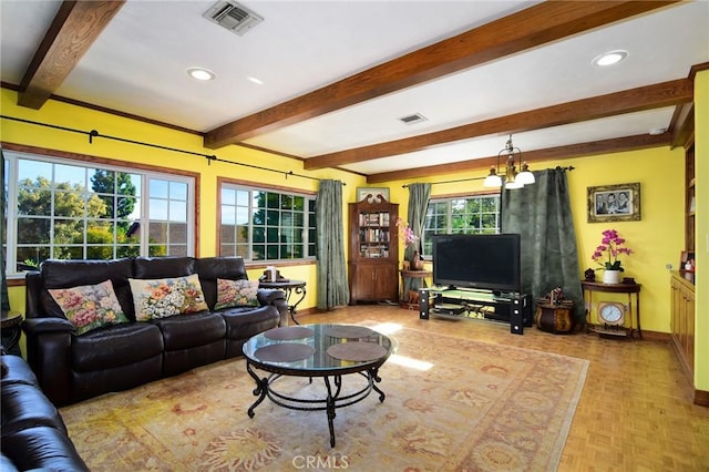 living room featuring plenty of natural light, beamed ceiling, and a notable chandelier