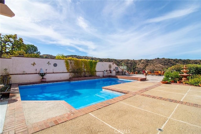 view of pool featuring a mountain view and a patio area