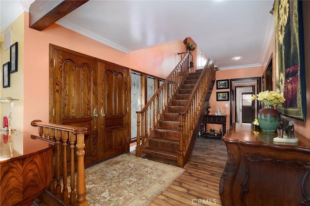 entrance foyer with crown molding and hardwood / wood-style flooring