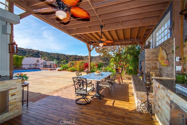 view of patio / terrace with a mountain view and ceiling fan