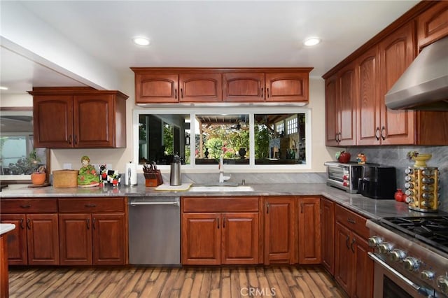 kitchen featuring backsplash, light hardwood / wood-style floors, extractor fan, and sink