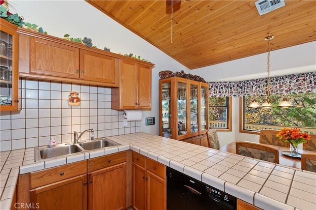 kitchen with pendant lighting, tile counters, lofted ceiling, and sink