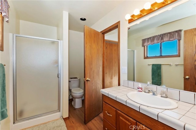 bathroom with toilet, vanity, an enclosed shower, and hardwood / wood-style flooring