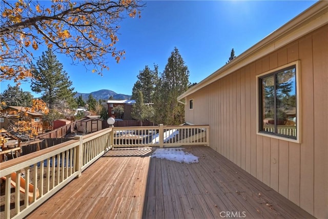 wooden deck featuring a mountain view and a shed