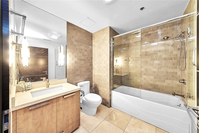 full bathroom featuring vanity, tile walls, tile patterned flooring, toilet, and tiled shower / bath