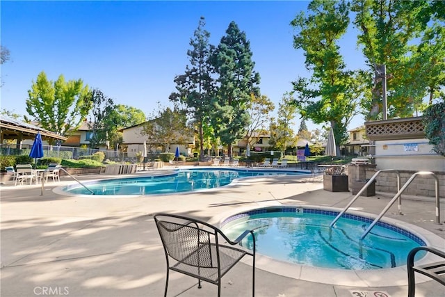 view of swimming pool featuring a patio area and a hot tub